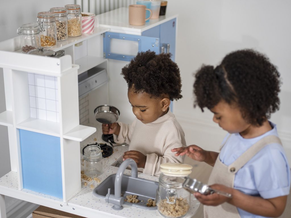 Children playing together in the Plum Penne Pantry Wooden Corner Kitchen with Fridge