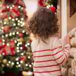 Child Looking at Christmas Tree outdoors