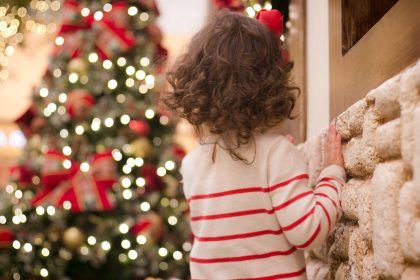 Child Looking at Christmas Tree outdoors