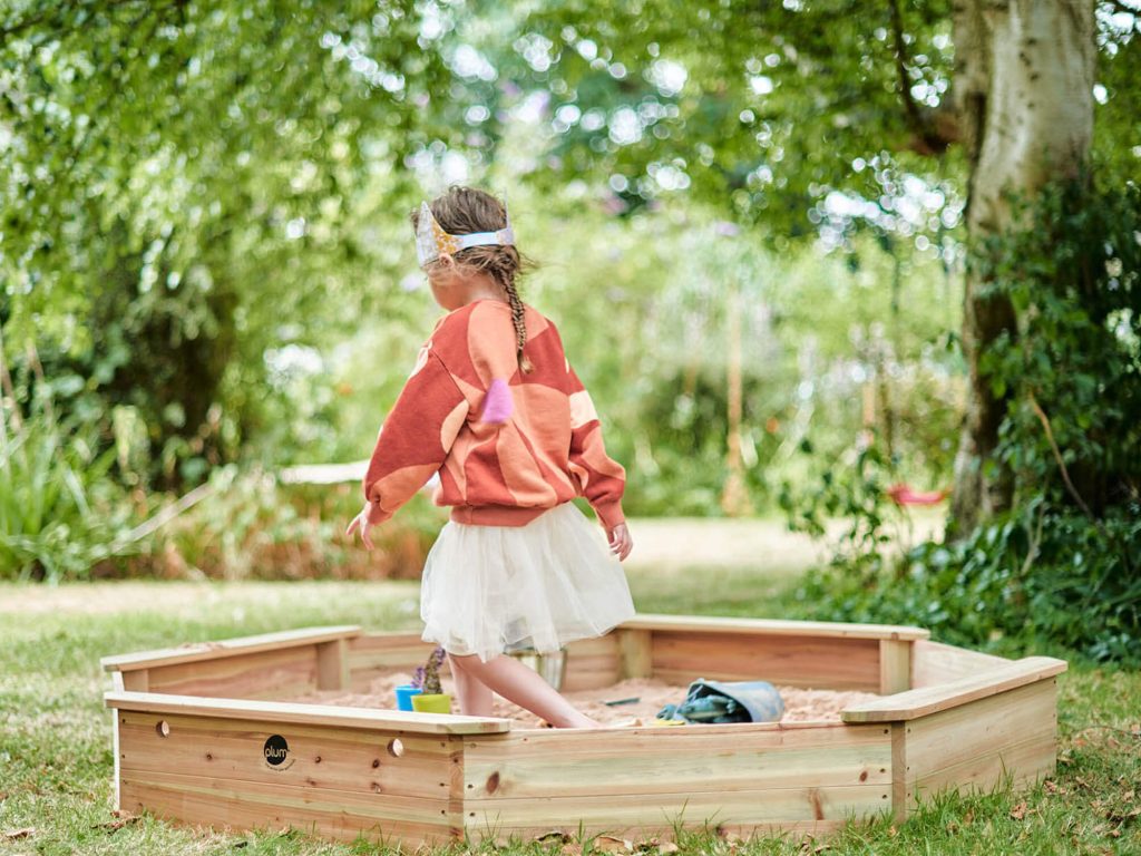 Child in Plum Play Giant Wooden Sandpit 