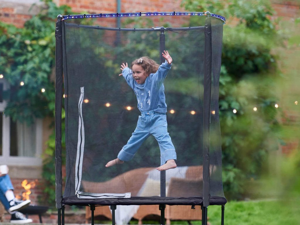 Child playing on Plum 4.5ft Interactive Lights Junior Trampoline and Enclosure 