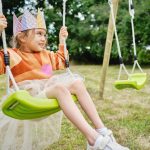 Child on swing with crown